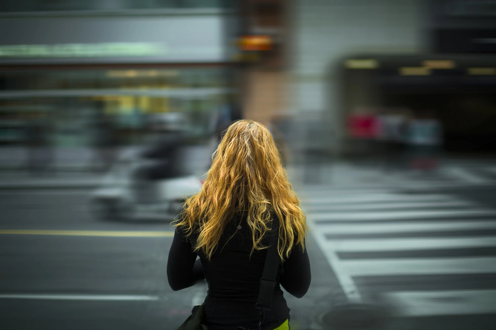 Mujer vista de espaldas cruzando un paso de peatones