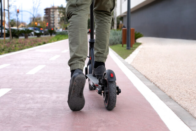 Chico en patinete eléctrico circulando por carril bici