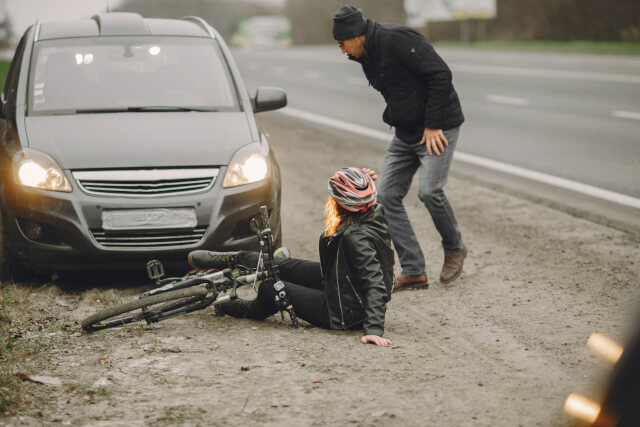 Mujer en bicicleta en el suelo por impacto con un vehículo